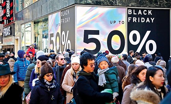 A crowd of people in front of a Black Friday sale sign